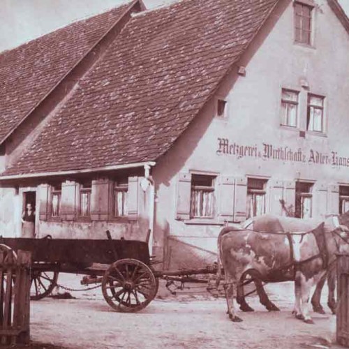 Altes Gebäude mit Pferden und Wagen